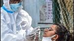 A health worker collects swab sample of passengers for Covid-19 test in Bengaluru on Sunday. (PTI) A health worker collects swab sample of passengers for Covid-19 test in Bengaluru on Sunday. (PTI)