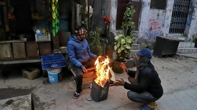 People sit around a bonfire to keep themselves warm on a cold winter morning, in New Delhi on Sunday.&nbsp; (Amit Sharma / ANI)