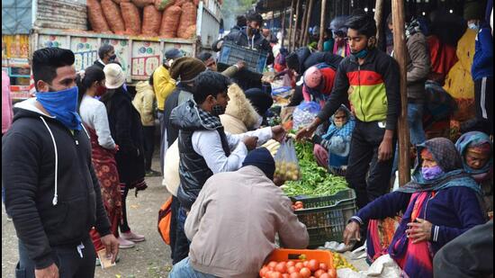 Customers and vegetable vendors ignoring mask and social distancing protocols at the wholesale vegetable market in Sector 26, Chandigarh, on Sunday. (Keshav Singh/HT)
