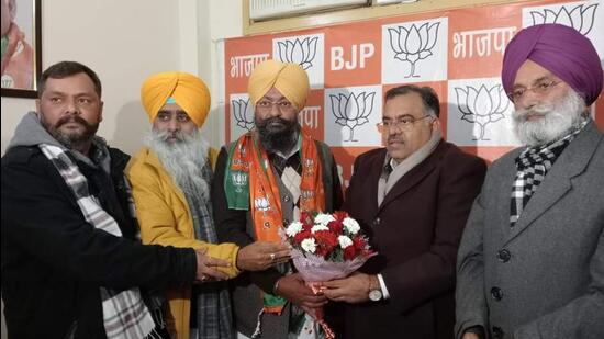 Congress Amritsar (rural) district president Bhagwant Pal Singh Sachar (centre) joined the BJP in the presence of its national general secretary Tarun Chugh on Sunday. (HT Photo)