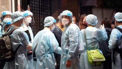 Workers wearing protective suits arrive to a building under lockdown. (REUTERS/Representative image)