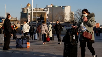 People wearing face masks, following the coronavirus disease (Covid-19) outbreak, walk outside Beijing Railway Station as the travel rush starts ahead of the Chinese Lunar New Year of the Tiger, also known as the Spring Festival, in Beijing, China &nbsp; (REUTERS/Carlos Garcia Rawlins)