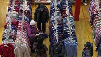 People wearing masks shop clothing during a promotion New Year sale at a mall in Beijing on Sunday. China’s economy expanded by 8.1% in 2021. (AP) People wearing masks shop clothing during a promotion New Year sale at a mall in Beijing on Sunday. China’s economy expanded by 8.1% in 2021. (AP)