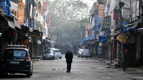 A man walking in the midst of a deserted Sarojini Nagar market during a weekend curfew in New Delhi on Sunday. (ANI Photo)(Shrikant Singh) A man walking in the midst of a deserted Sarojini Nagar market during a weekend curfew in New Delhi on Sunday. (ANI Photo)(Shrikant Singh)