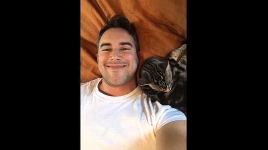 Screengrab from the cat video where the new cat dad couldn't help but smile at his feline friend. (reddit/@Interesting_Sale_847) Screengrab from the cat video where the new cat dad couldn't help but smile at his feline friend. (reddit/@Interesting_Sale_847)