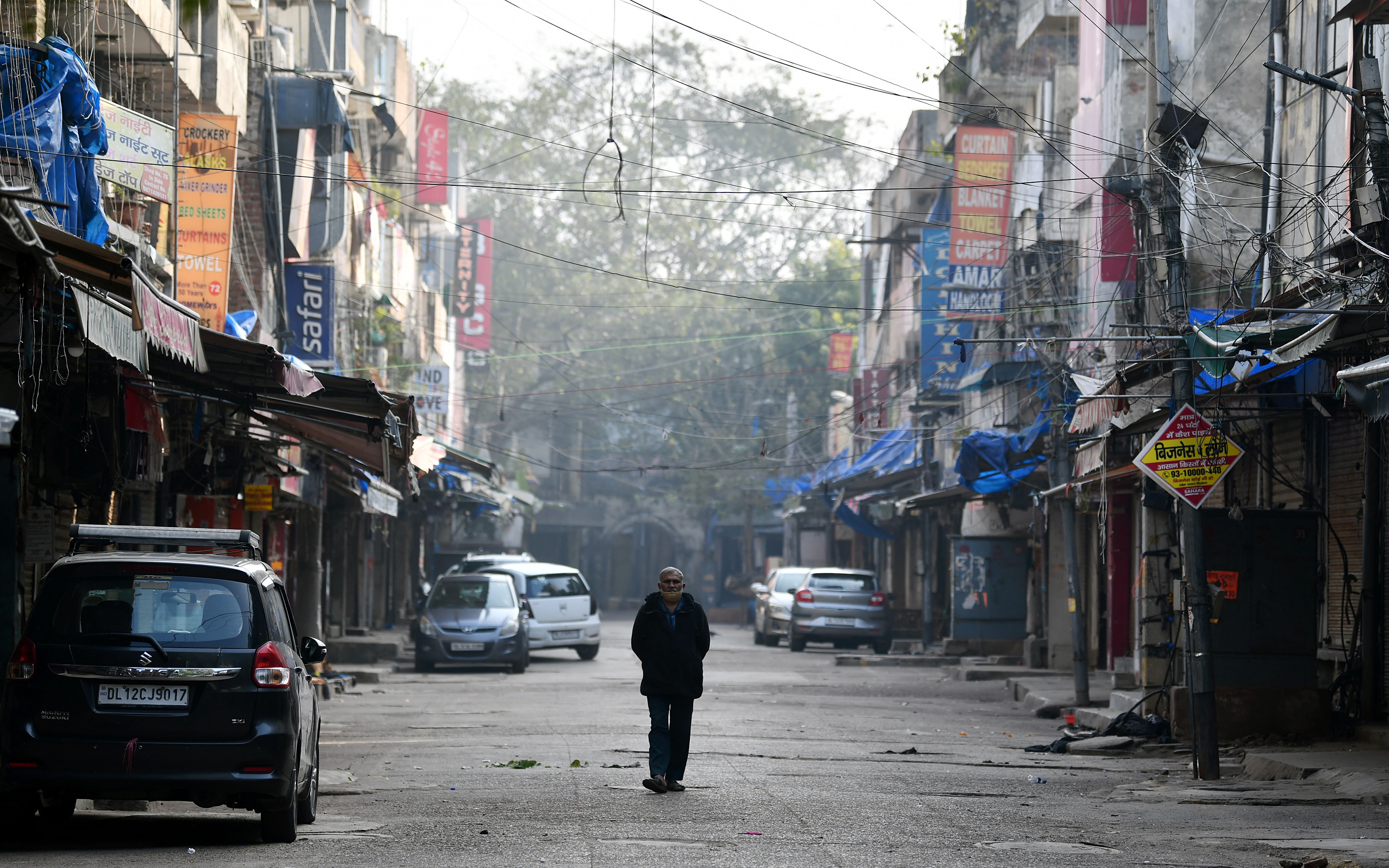 A man walking in the midst of a deserted Sarojini Nagar market during a weekend curfew in New Delhi. (ANI file photo) A man walking in the midst of a deserted Sarojini Nagar market during a weekend curfew in New Delhi. (ANI file photo)