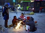 People huddle around a bonfire on a cold winter evening at Nizamuddin, on Tuesday. (Sanjeev Verma/HT PHOTO)