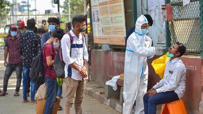 A health worker collects swab sample for Covid-19 test at KSR Railway Station in Bengaluru. (Agencies) A health worker collects swab sample for Covid-19 test at KSR Railway Station in Bengaluru. (Agencies)