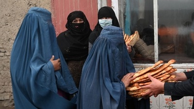 The United Nations has warned that half the country is threatened with food shortages. In picture - Women receive free bread distributed as part of the Save Afghans From Hunger campaign in front of a bakery in Kabul. (AFP)