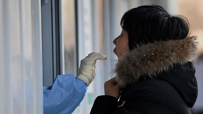 A medical worker gets a swab sample from a woman to test for Covid-19 at a swab collection site in Beijing on Monday. Canadian health authorities have dismissed the Chinese claim that an Omicron variant detected in Beijing may have been caused by a package received from Canada. (AFP) A medical worker gets a swab sample from a woman to test for Covid-19 at a swab collection site in Beijing on Monday. Canadian health authorities have dismissed the Chinese claim that an Omicron variant detected in Beijing may have been caused by a package received from Canada. (AFP)