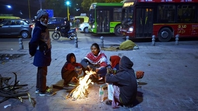 People huddle around a bonfire on a cold winter evening at Nizamuddin, on Tuesday. (Sanjeev Verma/HT PHOTO)