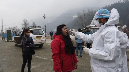 A health worker collects a swab sample from a tourist for Covid-19 test on the Srinagar-Sonamarg highway at Kangan, Jammu and Kashmir, on Tuesday. (Waseem Andrabi/HT)