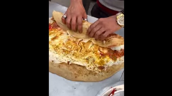The giant egg roll being served with 30 eggs, veggies and onions. (instagram/@oye.foodieee) The giant egg roll being served with 30 eggs, veggies and onions. (instagram/@oye.foodieee)