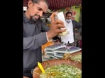 A man at a Nagpur eatery, grating some cheese into the flavoured water of the paani puri. (instagram/@food_o_logy_nagpur)