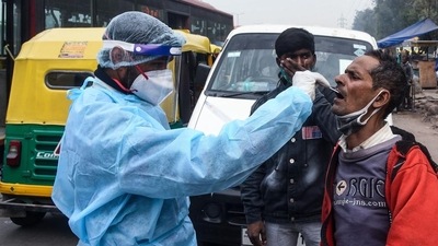 A health worker collects a swab sample from a person for coronavirus (Covid-19) test, at Jangpura in New Delhi. (HT Photo)