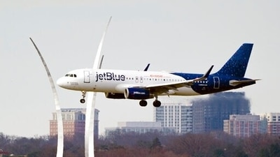 A JetBlue passenger flight passes the Air Force Memorial as it prepares to land at Reagan Washington National Airport in Arlington, Va., across the Potomac River from Washington, Wed., Jan. 19, 2022. (AP)