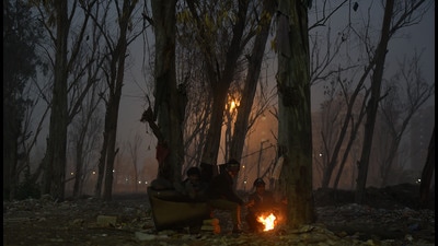 People huddle around a bonfire near Ghazipur, on Wednesday. (Raj K Raj/HT)