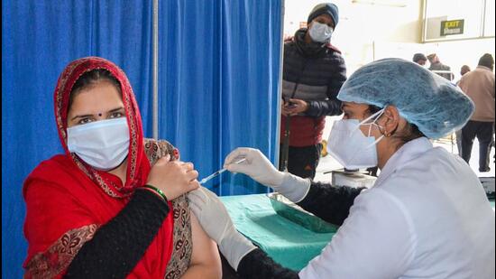 A healthworker administers a dose of Covid-19 vaccine to a beneficiary at a vaccination centre, in Gurugram. (PTI photo)