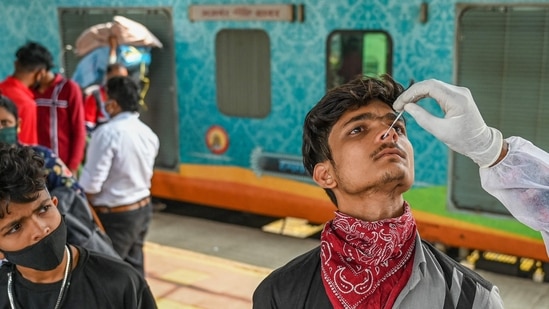 A health worker takes a nasal swab sample of a passenger during a Covid-19 coronavirus screening at a railway platform in Mumbai.(AFP)