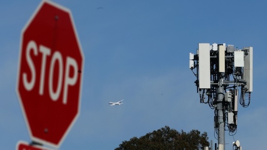 A plane flies by a cellular tower as it takes off from San Francisco International Airport on January 18, 2022, in San Bruno, California.&nbsp;(AFP)