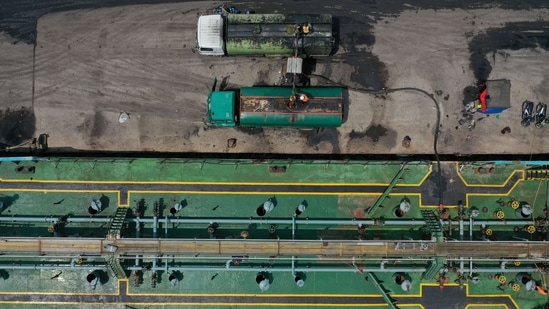Palm oil is loaded onto trucks from the Pangeran Palm oil tanker, bottom, docked at Karya Citra Nusantara Marunda Port in Jakarta.(Bloomberg Photo)