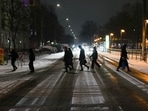 People cross a street at a public transport station after snow fall hit the German capital in Berlin, on Thursday.(AP Photo) People cross a street at a public transport station after snow fall hit the German capital in Berlin, on Thursday.(AP Photo)