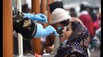 A woman gives her sample for Covid test at Dr Ram Manohar Lohia Hospital in Lucknow. (Deepak Gupta/HT Photo)