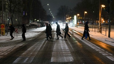 People cross a street at a public transport station after snow fall hit the German capital in Berlin, on Thursday. (AP Photo) People cross a street at a public transport station after snow fall hit the German capital in Berlin, on Thursday. (AP Photo)
