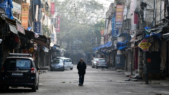 A man walking in the midst of a deserted Sarojini Nagar market during a weekend curfew in New Delhi on Sunday. (ANI Photo)