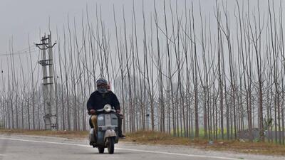 A commuter braves through the cold and rain in Ludhiana on Saturday. (Gurpreet Singh/HT)
