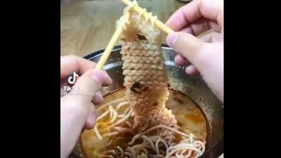 The image, taken from the viral video, shows someone knitting with noodles. (Screengrab)