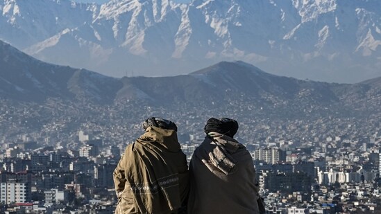 Members of the Taliban sit overlooking the Kabul city at the Wazir Akbar Khan hill in Kabul.(AFP)
