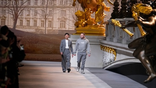 Kim Jones, right, acknowledges applause after the conclusion of the Dior fall-winter 22/23 men's collection, in Paris.&nbsp;(AP)