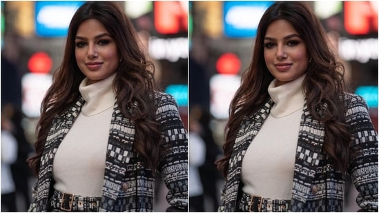 Harnaaz layered her ensemble with a long overcoat featuring black and white Aztec knitted details matching the skirt, notch lapels, long sleeves, ornate gold buttons and fitted silhouette. She rounded off her ensemble by wearing black stockings and ankle-high leather boots.(Instagram/@missuniverse)