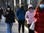 People wearing protective masks walk on a street during morning rush hour, as the Covid-19 pandemic continues in the country, in Beijing, China. (REUTERS) People wearing protective masks walk on a street during morning rush hour, as the Covid-19 pandemic continues in the country, in Beijing, China. (REUTERS)