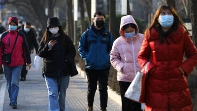 People wearing protective masks walk on a street during morning rush hour, as the Covid-19 pandemic continues in the country, in Beijing, China. (REUTERS) People wearing protective masks walk on a street during morning rush hour, as the Covid-19 pandemic continues in the country, in Beijing, China. (REUTERS)