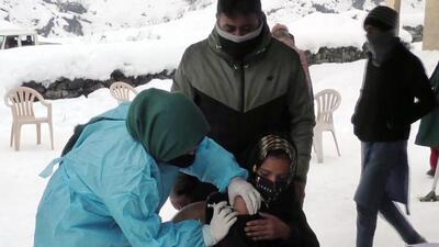 Baramulla, Jan 23 (ANI): A beneficiary receives a dose of the COVID-19 vaccine during a vaccination drive carried out by the healthcare workers with the help of the Indian Army during heavy snowfall, in Baramulla on Sunday. (ANI Photo) (ANI)