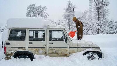 A boy uses a shovel to clear out snow from atop a vehicle after a snowfall at Hirpora village in south Kashmir’s Shopian district, 70 km from Srinagar, on Sunday. Traffic officials said that the Jammu-Srinagar National Highway was blocked owing to landslides after the snowfall during the night. (AFP) A boy uses a shovel to clear out snow from atop a vehicle after a snowfall at Hirpora village in south Kashmir’s Shopian district, 70 km from Srinagar, on Sunday. Traffic officials said that the Jammu-Srinagar National Highway was blocked owing to landslides after the snowfall during the night. (AFP)