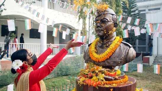 A girl showers flower petals as she pays tribute to the statue of Netaji Subhas Chandra Bose on his 125th birth anniversary, in Agartala.(ANI)