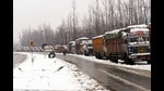 Stranded trucks seen parked in a queue on the Srinagar-Jammu National Highway after a fresh snowfall, in Qazigund, South Kashmir on Sunday. A landslide on Monday blocked the Jammu-Srinagar highway at Seri in Ramban district. (ANI)