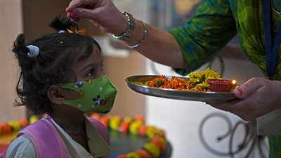 A teacher traditionally welcomes a student upon her arrival at a school in Mumbai on January 24. (AFP) A teacher traditionally welcomes a student upon her arrival at a school in Mumbai on January 24. (AFP)