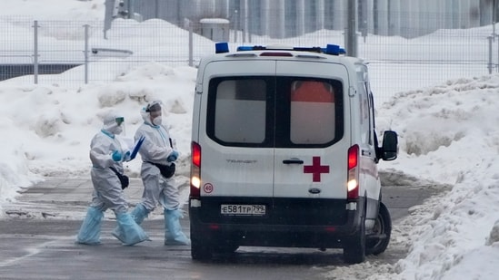 Medical workers walk to an ambulance at a hospital in Kommunarka, outside Moscow, Russia, Sunday, Jan. 23, 2022.&nbsp;(AP Photo)