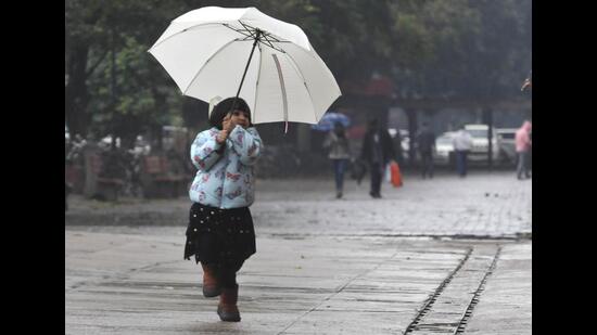 A girl enjoying the rain at the Sector 17 Plaza in Chandigarh on Sunday. (Keshav Singh/HT)