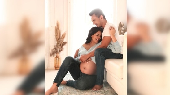 In the picture, Shweta Agarwal can be seen flaunting her baby bump while Aditya Narayan holds his wife in his arms and they both smile.(Instagram/@adityanarayanofficial)