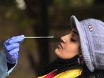 A health worker collects swab samples of a woman for Covid testing. A health worker collects swab samples of a woman for Covid testing.