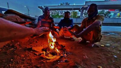 People sitting around a bonfire to beat the cold. (HT PHOTO) People sitting around a bonfire to beat the cold. (HT PHOTO)