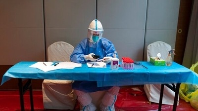 A medical worker in protective gear prepares a tube for a Covid-19 test at a testing site set up. (AP) A medical worker in protective gear prepares a tube for a Covid-19 test at a testing site set up. (AP)