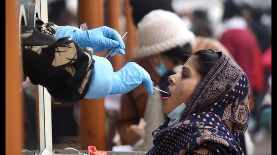 A woman gives sample for Covid test at Ram Manohar Lohia Institute in Lucknow. (HT File Photo)