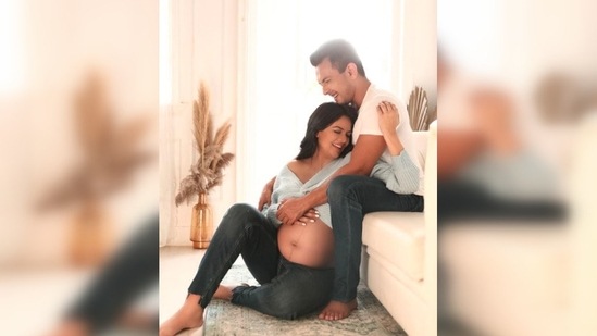 In the picture, Shweta Agarwal can be seen flaunting her baby bump while Aditya Narayan holds his wife in his arms and they both smile.(Instagram/@adityanarayanofficial)