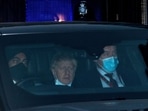 Britain's Prime Minister Boris Johnson wearing a face covering but pulled down under his chin, sits in the back of a car as he is driven away from the Houses of Parliament.